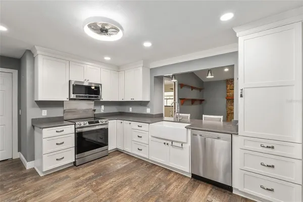 a kitchen with white cabinets and sink