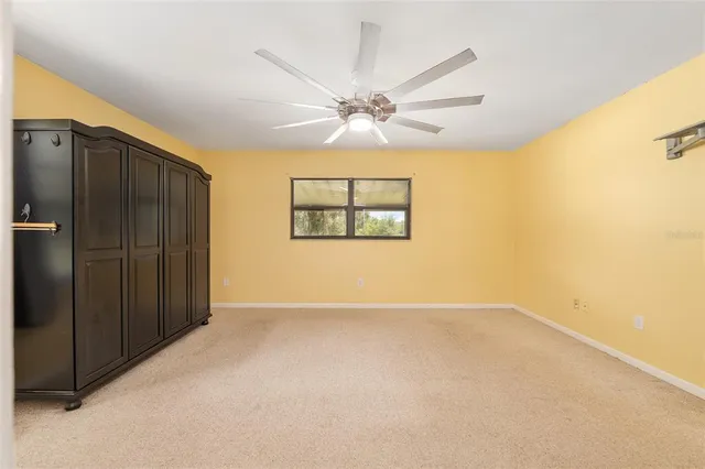 an empty room with closet and a ceiling fan