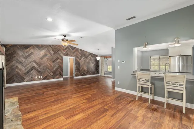 an empty room with a ceiling fan and windows