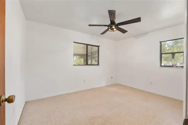 a view of a hallway with wooden floor and a bathroom