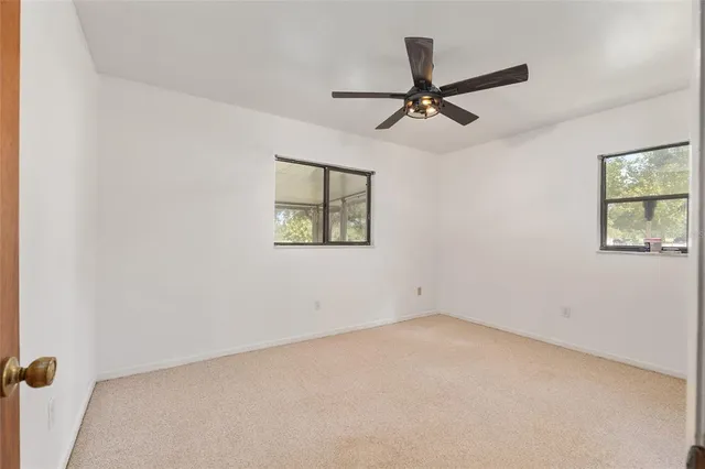 a view of a hallway with wooden floor and a bathroom