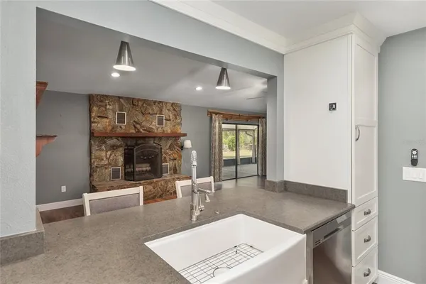 a living room with stainless steel appliances kitchen island furniture and a fireplace