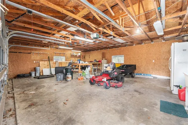 a view of swimming pool with lawn chairs and large trees
