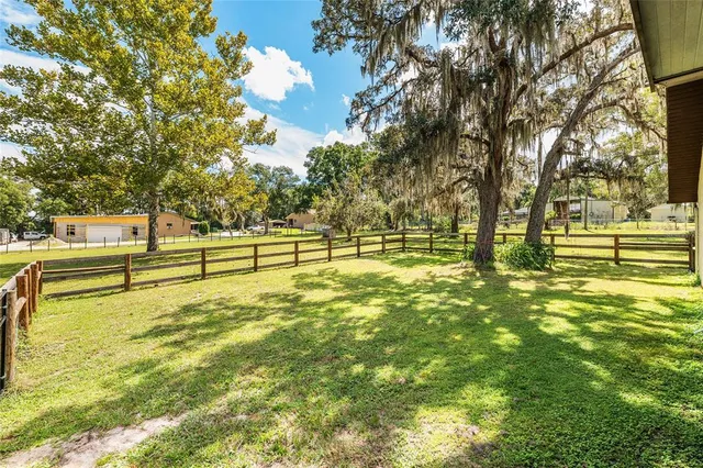 a view of a house with a yard and sitting area