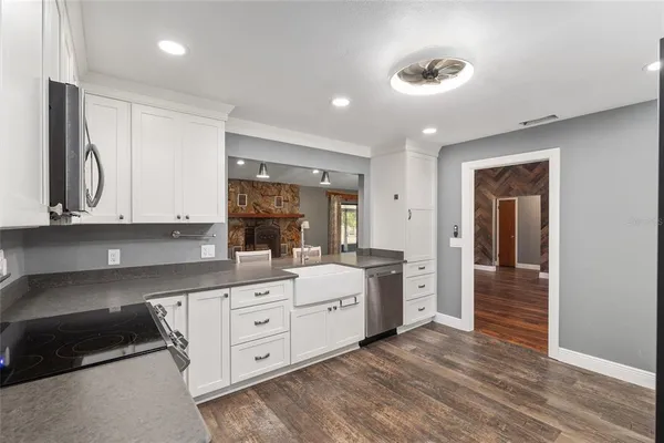 a large kitchen with cabinets and wooden floor