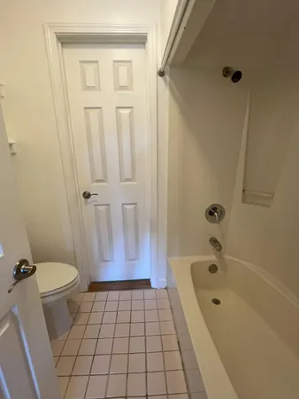 a bathroom with a granite countertop bathtub and toilet