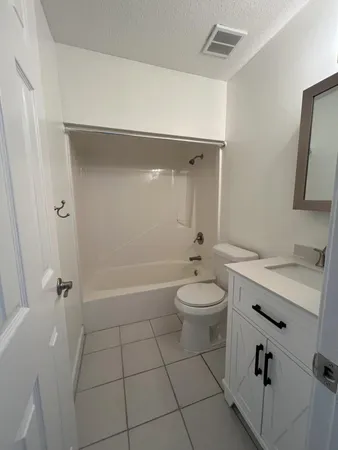 a bathroom with a granite countertop sink a toilet and shower