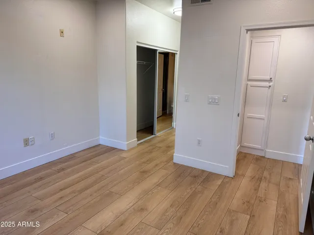 an empty room with wooden floor and closet