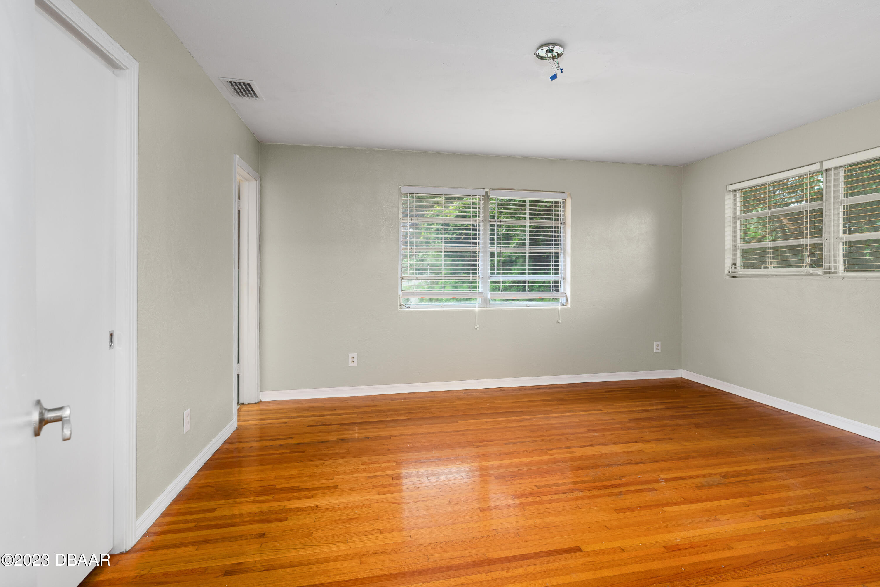267 South Halifax Drive Ormond Beach, FL 32176 - Photo 25 of 47 a view of an empty room with wooden floor and a window