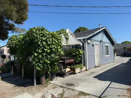 a view of a house with a small yard and potted plants