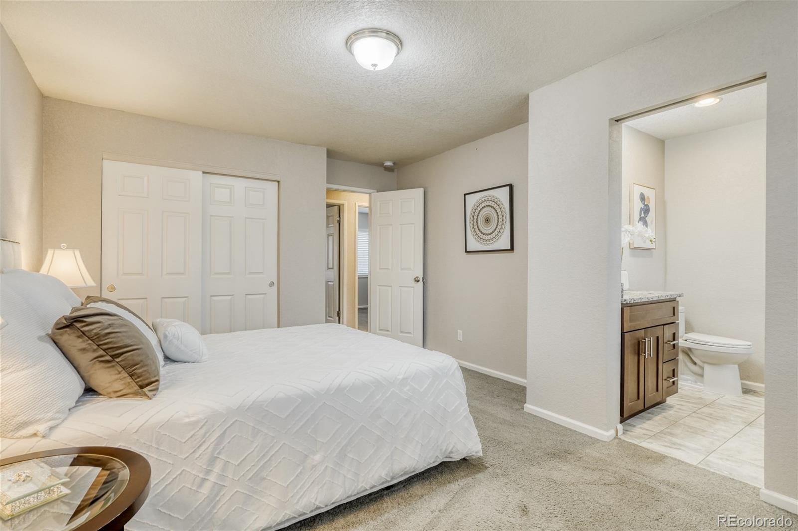 2682 South Quintero Way Aurora, CO 80013 - Photo 13 of 25 a bedroom with a bed and a lamp
