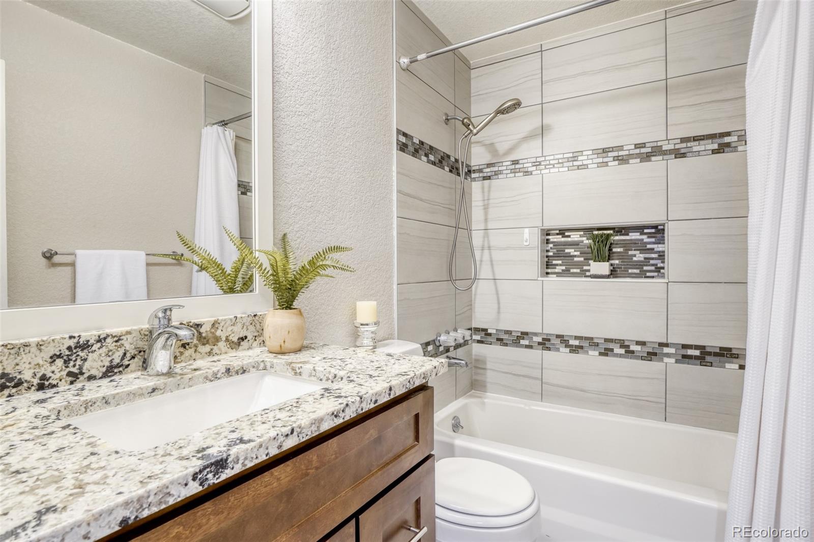 2682 South Quintero Way Aurora, CO 80013 - Photo 17 of 25 a bathroom with a granite countertop sink a toilet and bathtub