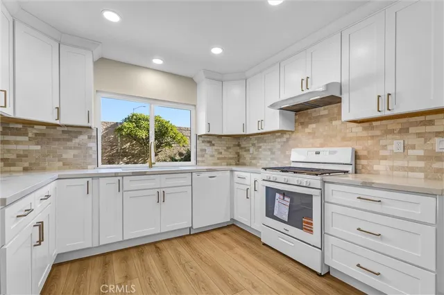 a kitchen with granite countertop white cabinets and white appliances
