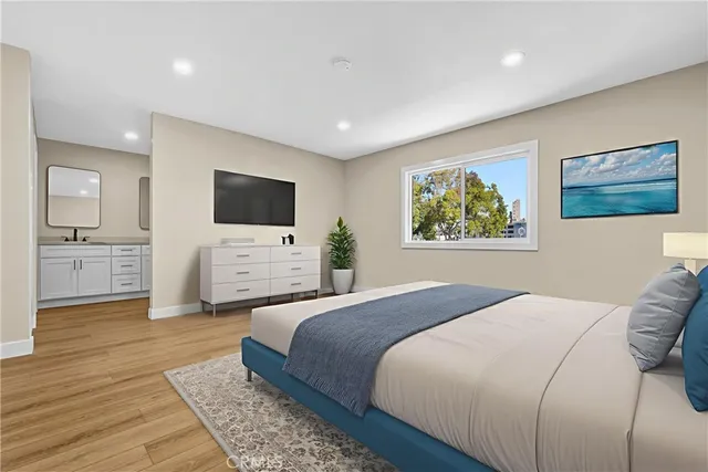 a spacious bedroom with a large bed a flat tv screen and a dresser