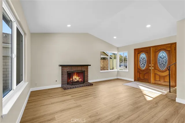 a view of an empty room with window and fire place