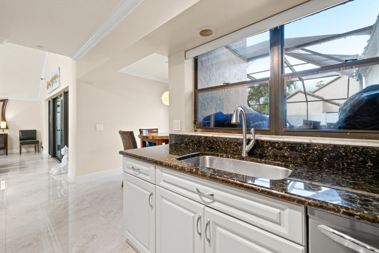 22313 Ensenada Way Boca Raton, FL 33433 - Photo 11 of 44 a kitchen with stainless steel appliances granite countertop a sink and a wooden cabinets