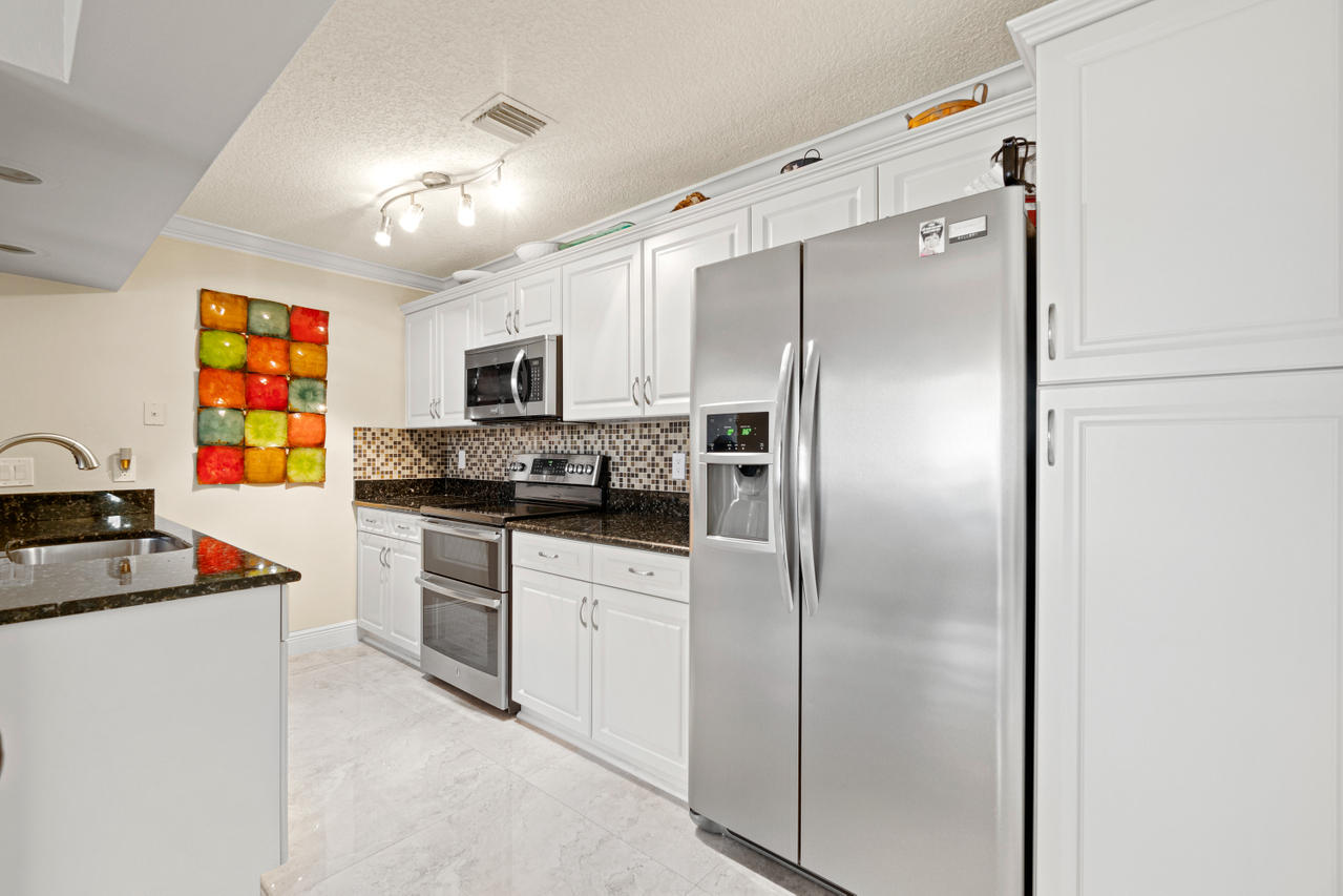 22313 Ensenada Way Boca Raton, FL 33433 - Photo 13 of 44 a kitchen with stainless steel appliances a refrigerator sink and stove