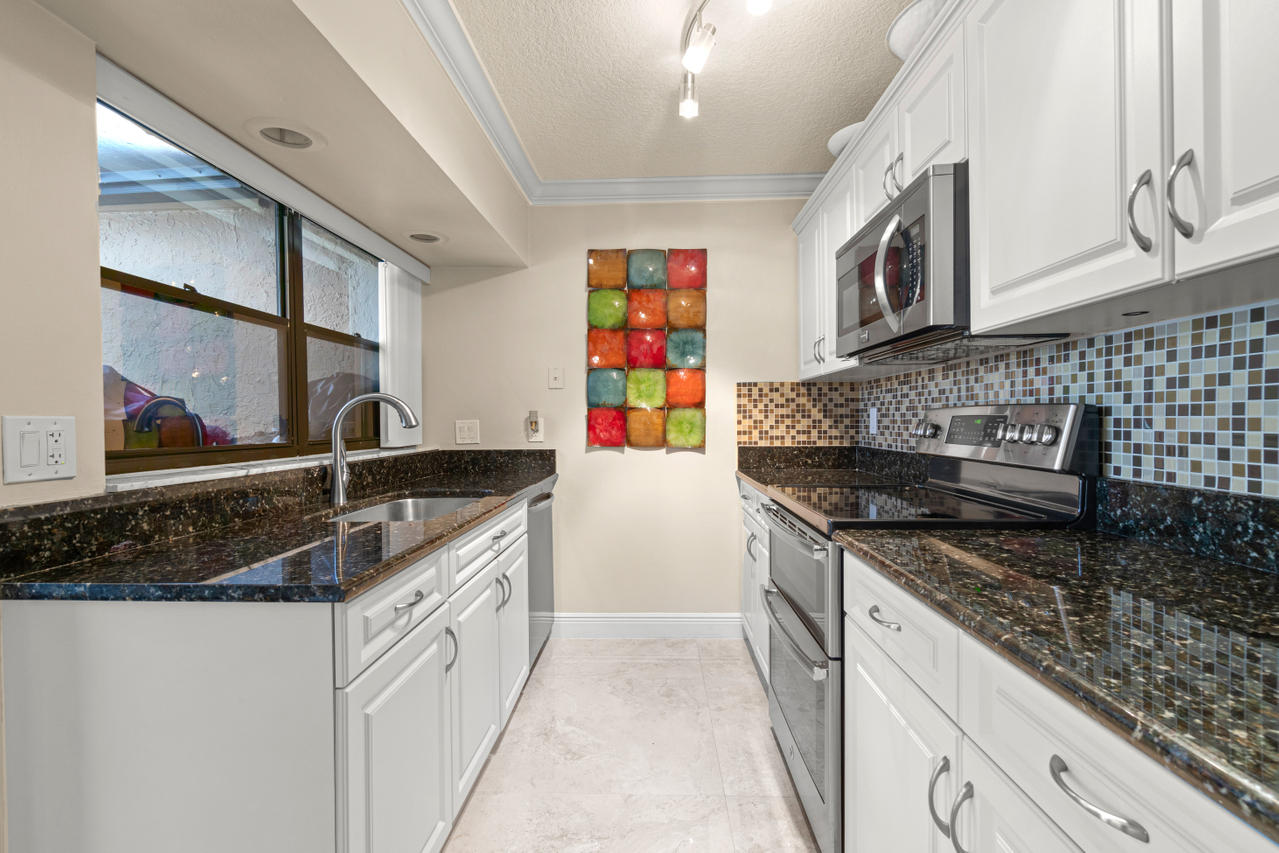 22313 Ensenada Way Boca Raton, FL 33433 - Photo 14 of 44 a kitchen with stainless steel appliances granite countertop a sink and a stove