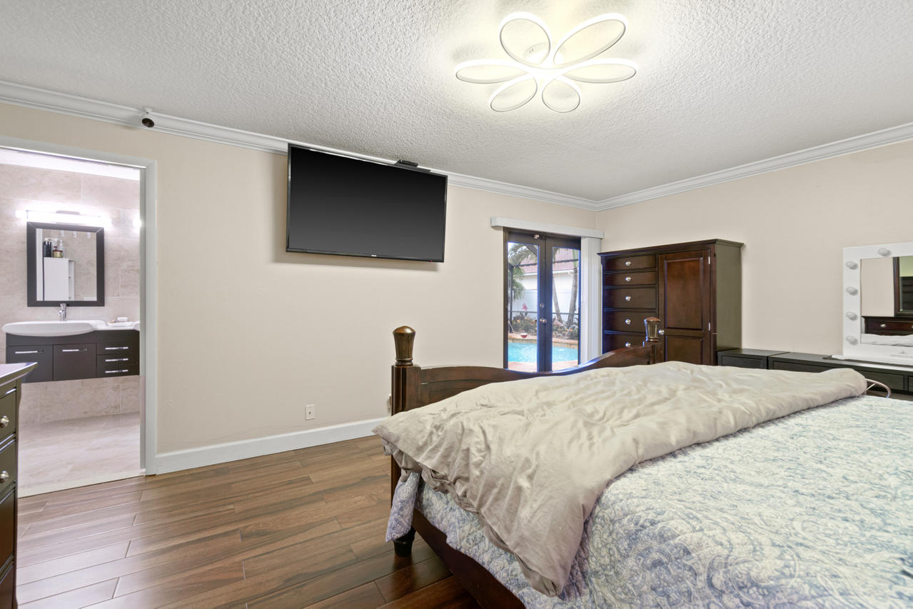 22313 Ensenada Way Boca Raton, FL 33433 - Photo 29 of 44 a bedroom with a bed and a chandelier