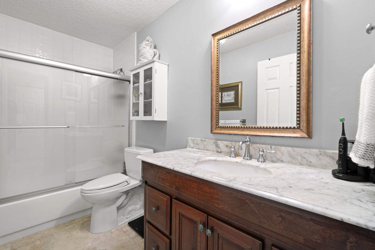 22313 Ensenada Way Boca Raton, FL 33433 - Photo 34 of 44 a bathroom with a granite countertop sink a toilet and shower