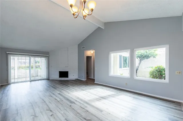an empty room with wooden floor and fireplace