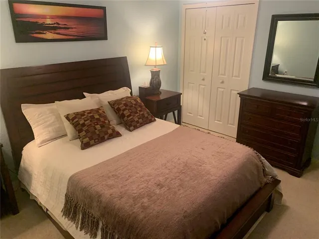 a bedroom with a bed and a painting on the wall