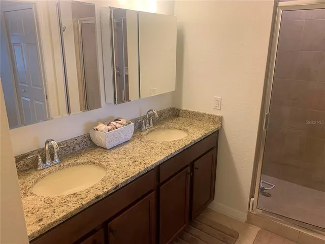 a bathroom with a granite countertop sink and a mirror