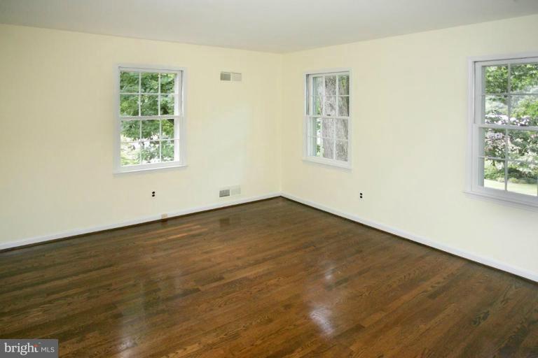 7912 Greentree Road Bethesda, MD 20817 - Photo 16 of 23 an empty room with wooden floor and windows