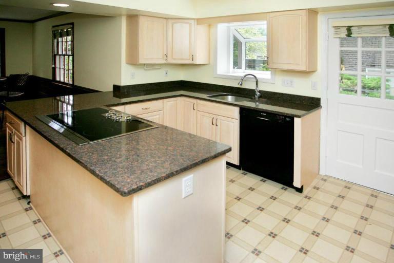 7912 Greentree Road Bethesda, MD 20817 - Photo 5 of 23 a kitchen with granite countertop a sink stainless steel appliances a window and a counter top space