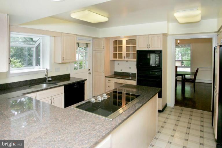 7912 Greentree Road Bethesda, MD 20817 - Photo 7 of 23 a kitchen with granite countertop a stove a sink and a refrigerator