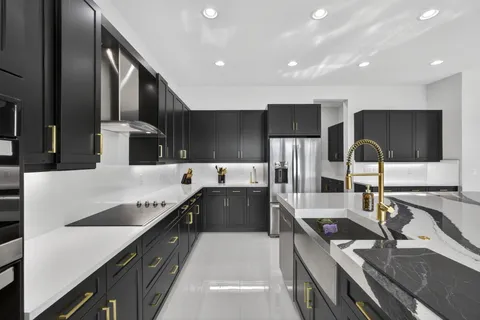 a large kitchen with stainless steel appliances a sink and a stove