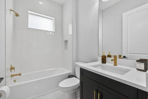 a bathroom with a sink a toilet a mirror a bathtub and shower