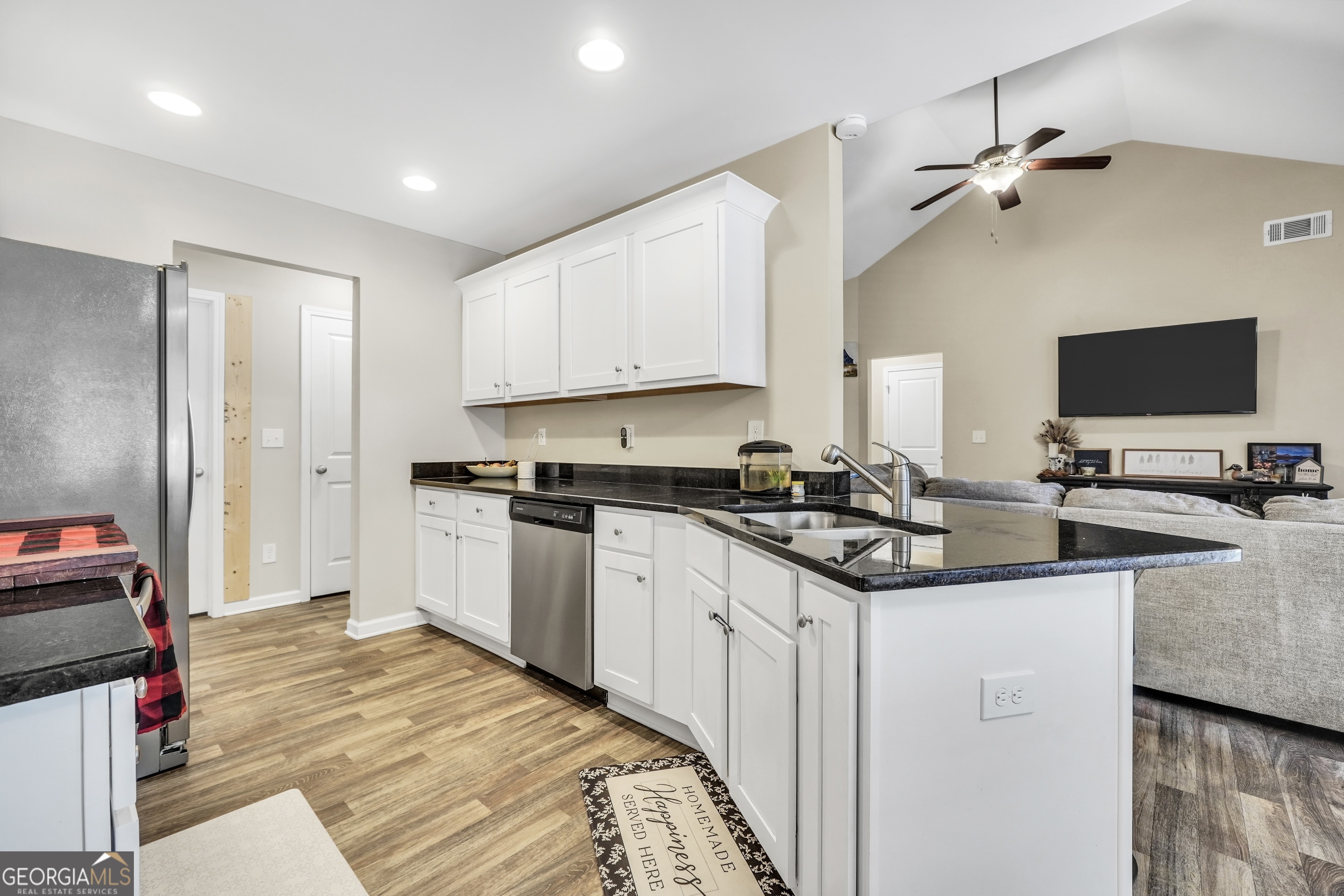 129 Magnolia Trail Milner, GA 30257 - Photo 9 of 29 a kitchen with stainless steel appliances kitchen island granite countertop a sink and cabinets