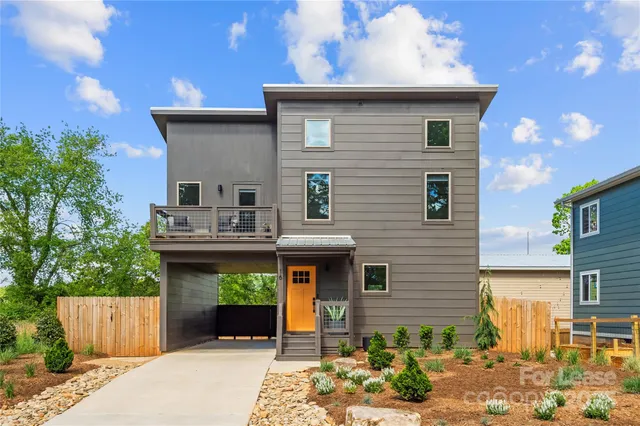 a view of a house with potted plants and a table