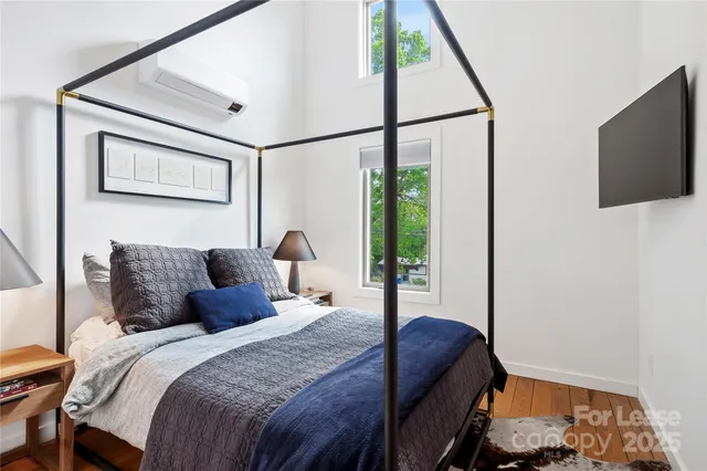 a bedroom with a bed and a flat tv screen on dresser