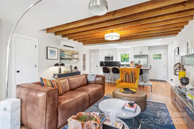 a living room with furniture kitchen view and a chandelier