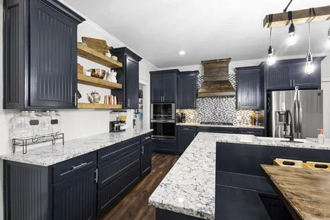 a kitchen with granite countertop wooden cabinets and stainless steel appliances