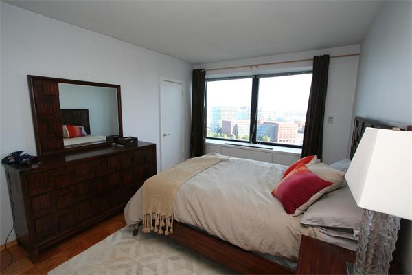 85 East India Row, Unit 25D Boston, MA 02110 - Photo 4 of 8 a bedroom with a bed and a flat tv screen on dresser