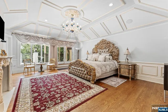 a bedroom with a large bed and a chandelier