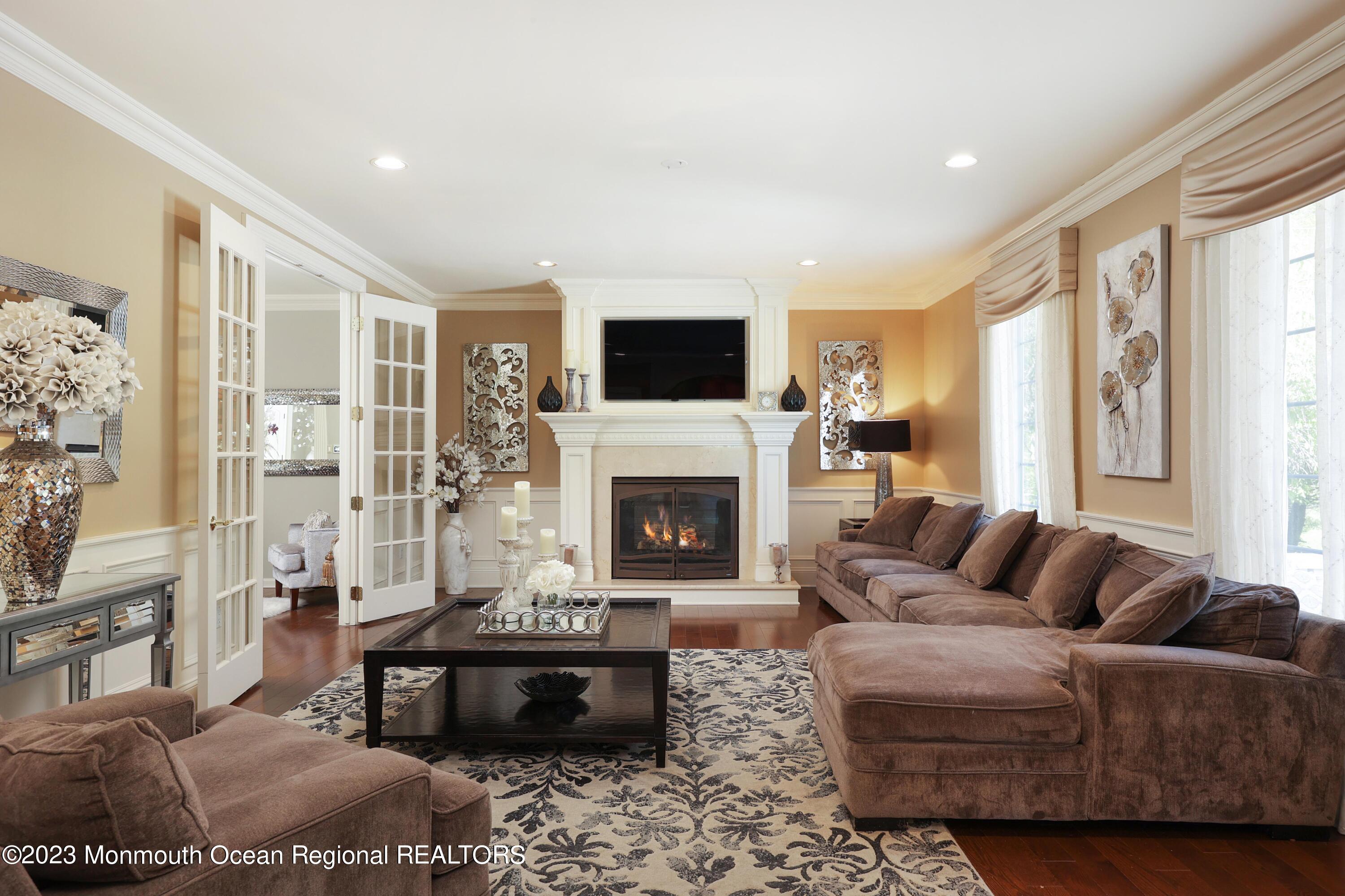 8 Old Stable Way Colts Neck, NJ 07722 - Photo 18 of 45 a living room with furniture a flat screen tv and a fireplace