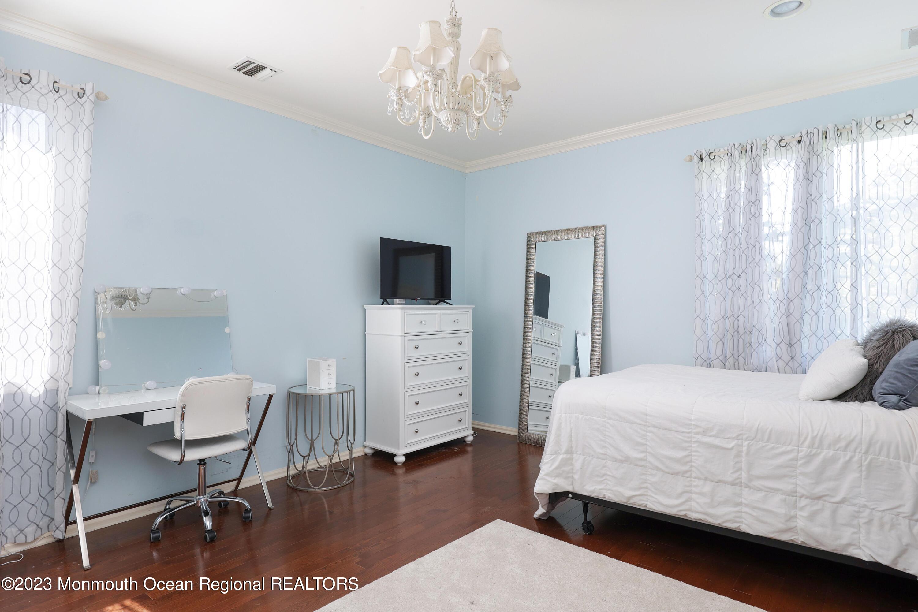 8 Old Stable Way Colts Neck, NJ 07722 - Photo 24 of 45 a bedroom with a bed and a chair in it