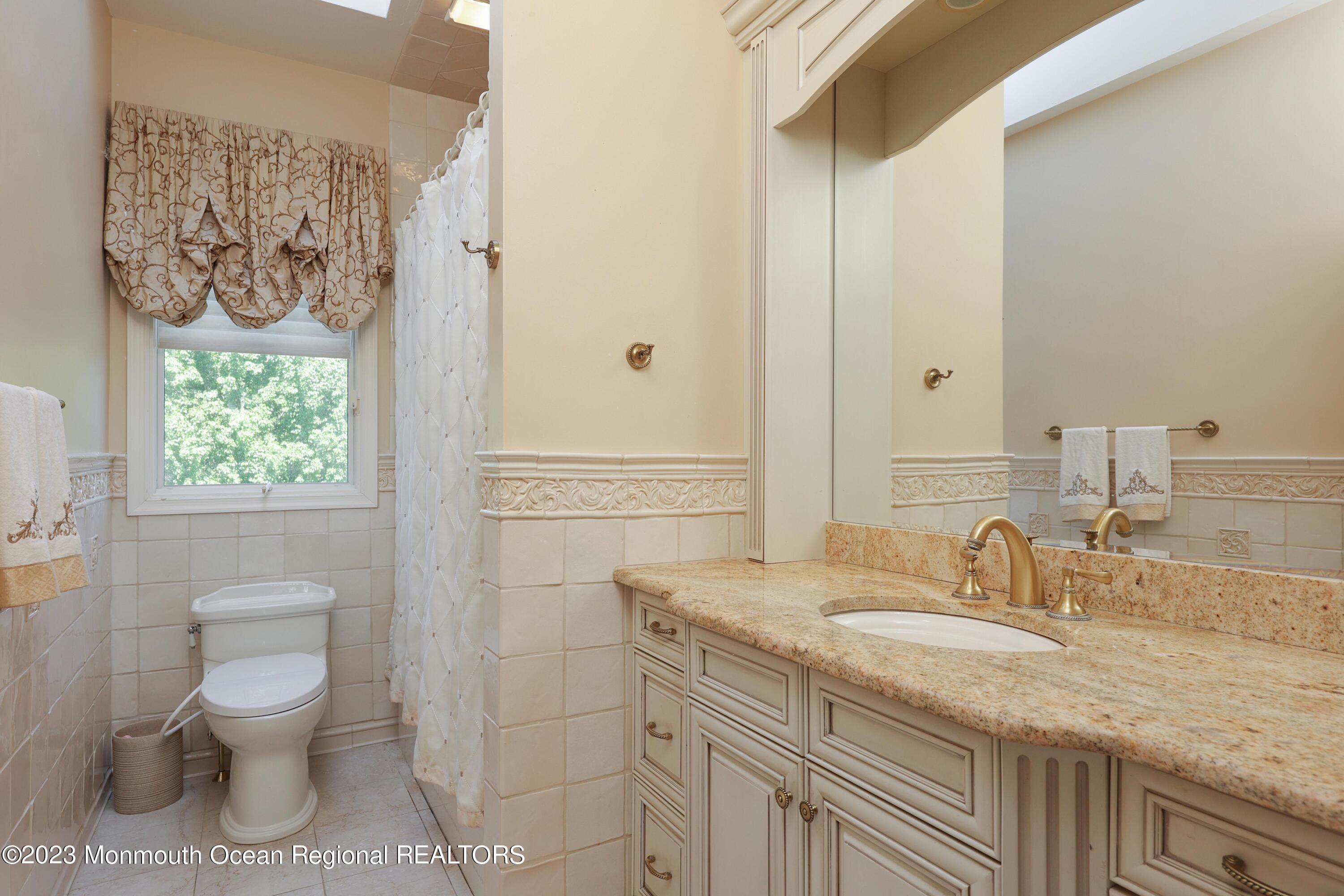 8 Old Stable Way Colts Neck, NJ 07722 - Photo 27 of 45 a bathroom with a granite countertop sink toilet and painting on the wall
