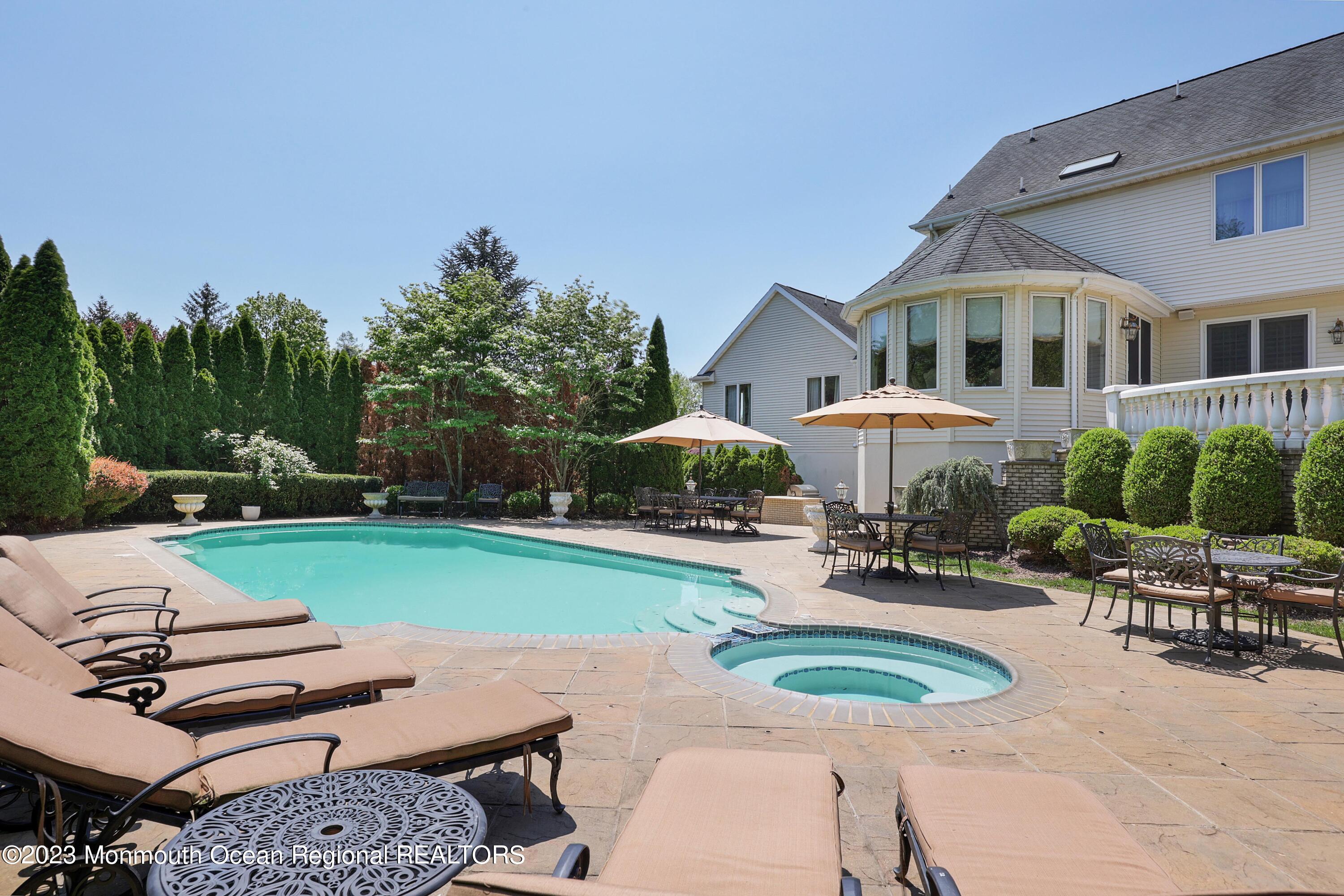 8 Old Stable Way Colts Neck, NJ 07722 - Photo 34 of 45 a front view of a house with garden and patio