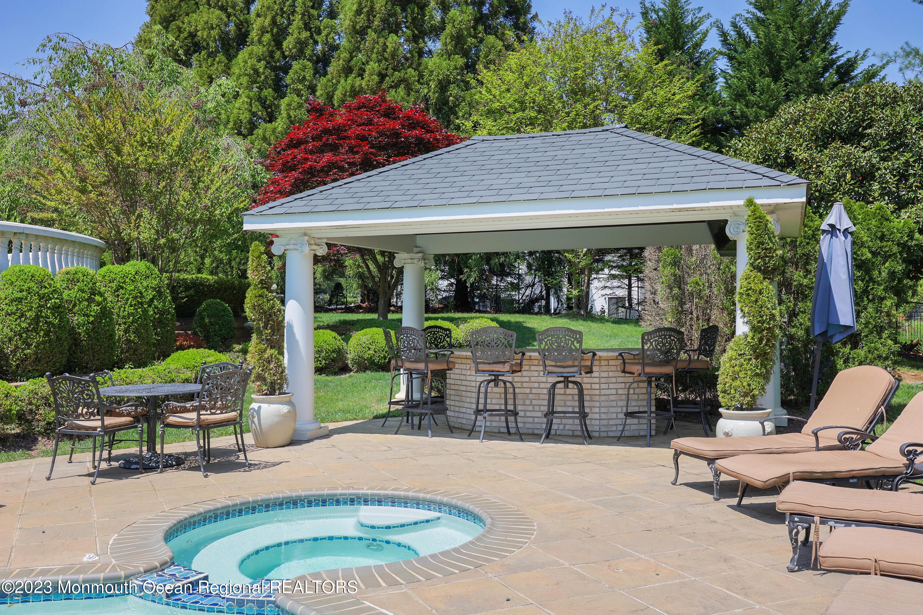 8 Old Stable Way Colts Neck, NJ 07722 - Photo 38 of 45 a patio with a table and chairs under an umbrella