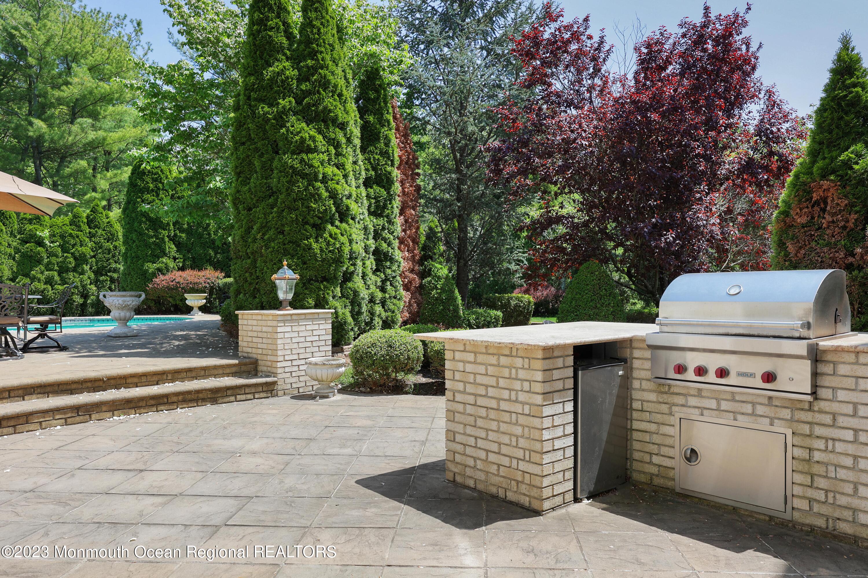 8 Old Stable Way Colts Neck, NJ 07722 - Photo 40 of 45 a view of a patio with table and chairs potted plants and large tree