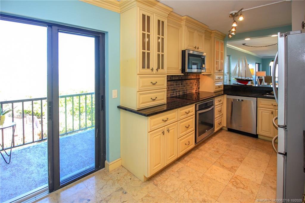 2571 Northeast Ocean Boulevard, Unit 10203 Stuart, FL 34996 - Photo 17 of 46 a kitchen with stainless steel appliances granite countertop a refrigerator and a stove top oven