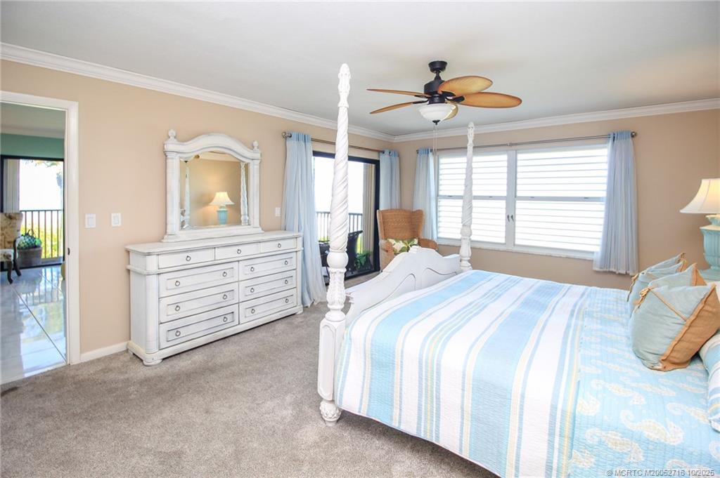 2571 Northeast Ocean Boulevard, Unit 10203 Stuart, FL 34996 - Photo 22 of 46 a spacious bedroom with a bed a dresser and a chandelier