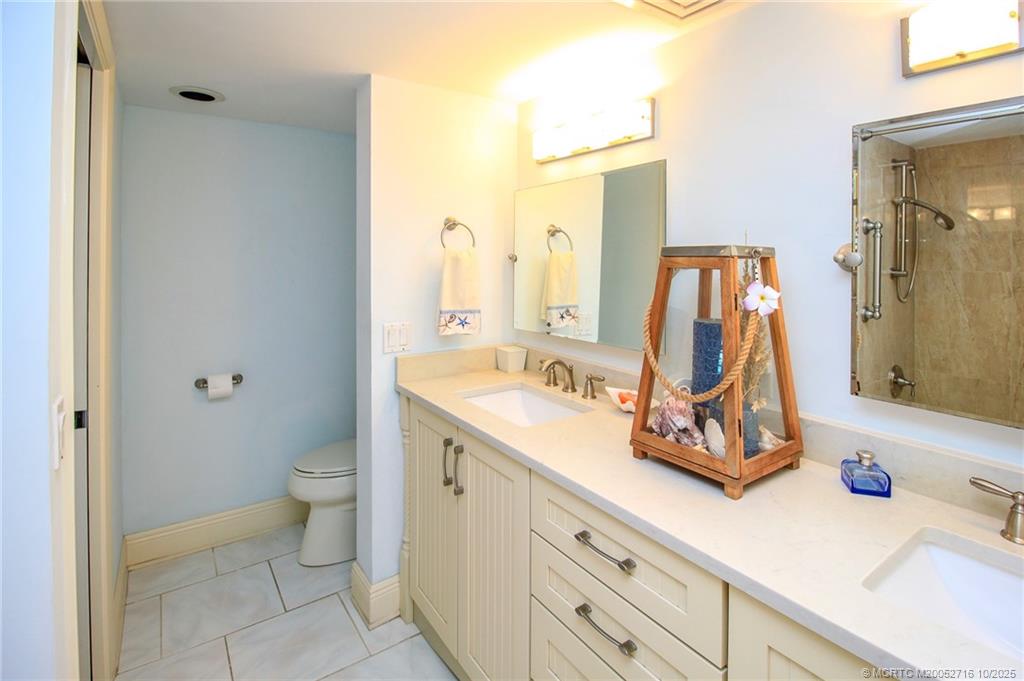 2571 Northeast Ocean Boulevard, Unit 10203 Stuart, FL 34996 - Photo 30 of 46 a bath room with a sink and a mirror