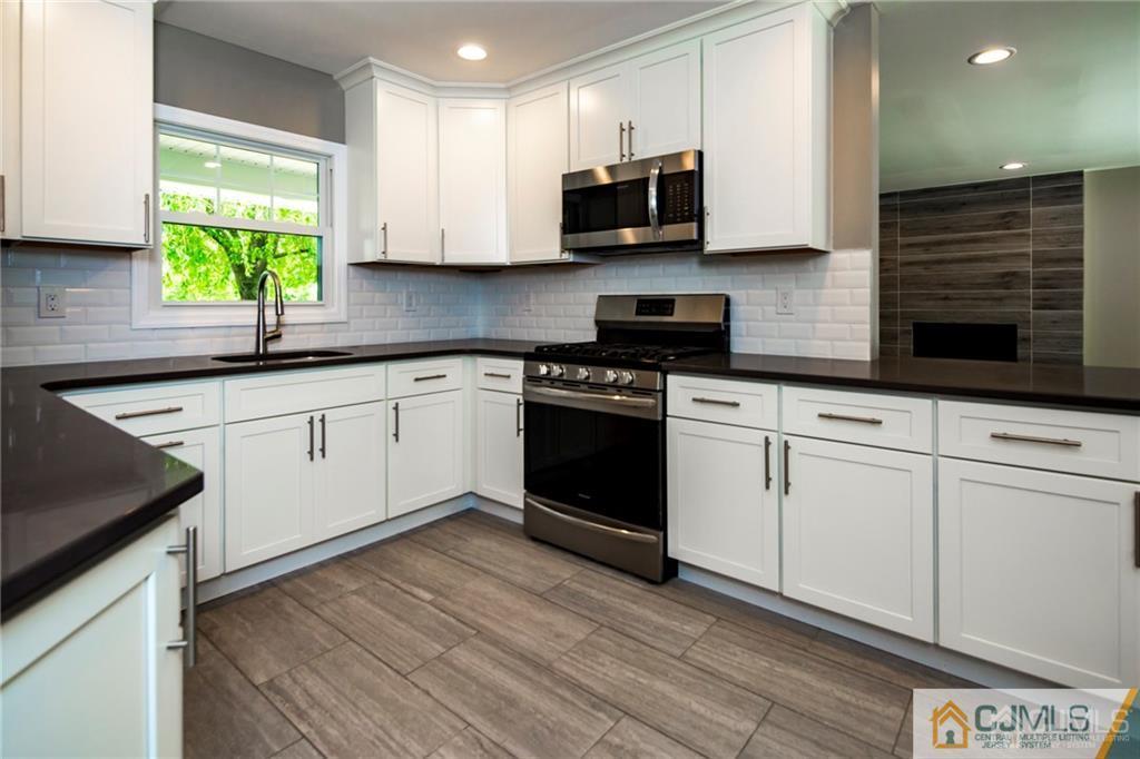9 Edgewood Road Old Bridge, NJ 07747 - Photo 16 of 35 a kitchen with stainless steel appliances granite countertop a stove a sink and a microwave