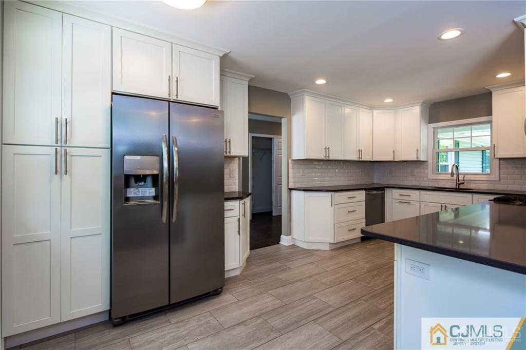 9 Edgewood Road Old Bridge, NJ 07747 - Photo 17 of 35 a kitchen with stainless steel appliances granite countertop a refrigerator a sink and white cabinets